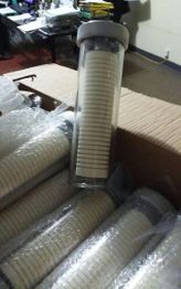 Cilindro de vidro com discos empilhados em cima de caixas de papelão em um ambiente de escritório.