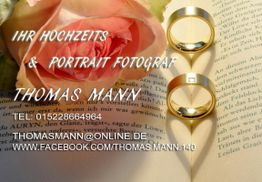 Rosenblüte und Ringe auf Buchseiten mit Kontaktdaten eines Hochzeitsfotografen.