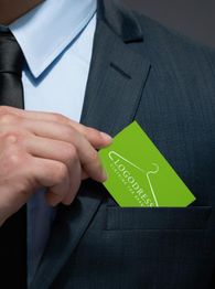 Mann in Anzug steckt grüne Karte mit Kleiderbügel-Logo in die Brusttasche.
