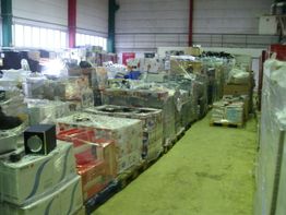 Lagerhalle mit dicht gestapelten Paletten voller verpackter Ware und Kartons.