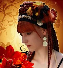 Frau mit rotem Haar und Kopfschmuck aus Federn und Muscheln vor floralem, gelbem Hintergrund.