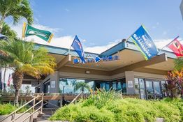 A building with sports team flags and palm trees, labeled "DIAMONDS," under a blue sky.