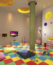 Sala de juegos infantil con alfombra colorida, cojines y pantallas en las paredes.