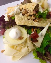 Ensalada con lechuga, manzana, frutos secos, queso y trozos de pan crujiente.