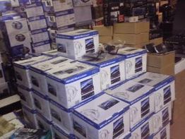 Viele gestapelte Kartons mit Elektronikartikeln in einem Geschäft.