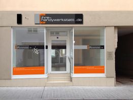 Ladenfront einer Handywerkstatt mit großen Fenstern und einem Schild mit der Aufschrift "Ihre Handywerkstatt".