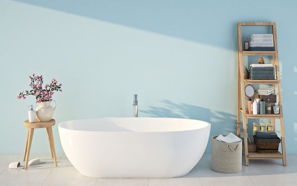 Ein blau gestrichenes Badezimmer. In der Mitte steht eine Badewanne, daneben ein Regal.