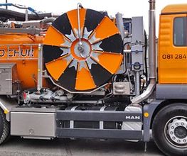 Oranger Kanalreinigungs-Lkw mit einer großen Schlauchtrommel an der Seite, beschriftet mit LAO Chur.