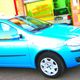 Auto blu parcheggiata davanti a un edificio dai colori vivaci.