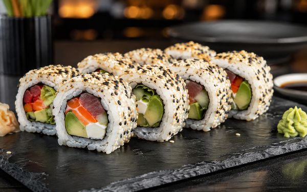Bunt befüllte Ura Maki Rolle ummantelt mit dunklem und hellem Sesam.