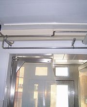 Industriell gestalteter Raum mit Rohren an der Decke und einer verschlossenen Metalltür.