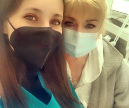 Dos personas con mascarillas en entorno clínico se toman una selfie.
