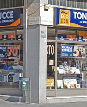 Negozio angolare Eco Store che vende cartucce e toner per stampanti, con vari cartelli promozionali.