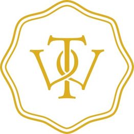 Emblem in Gold mit überlappenden Buchstaben W und T, umringt von einer geschwungenen Linie.