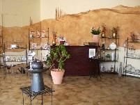 Geschäftsraum mit Regalen, Topfpflanze und einer rustikalen braunen Wand mit Dekorationen.