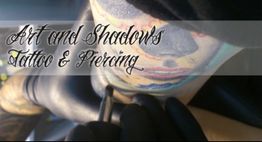 Eine Person bekommt ein farbiges Tattoo. Text: "Art and Shadows Tattoo & Piercing".