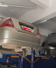 Carros em plataforma elevatória em uma oficina mecânica.