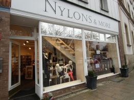 Ladenfront mit Schaufensterpuppen und Schilderlebnis "Nylons & More".
