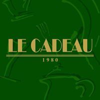 Testo dorato "LE CADEAU 1980" su sfondo verde con decorazioni astratte.