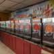 Bank of daiquiri machines with colorful drink options under a "Fine Wine & Liquor" sign.