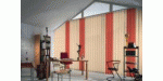 Modernes Büro mit großen Fensterjalousien, Schreibtisch, Stühlen und Regalen.