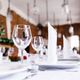 Elegant table setting with wine glasses and folded napkins in a bright restaurant.