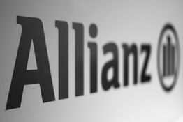 Schwarz-weißes Allianz-Logo mit stilisiertem Gebäude auf einer glatten Oberfläche.