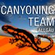 Ein schwarz-orangener Salamander vor einem Himmel mit der Aufschrift "Canyoning Team Allgäu".