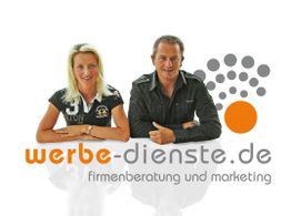 Zwei Personen sitzen hinter dem Logo von "werbe-dienste.de" für Unternehmensberatung.