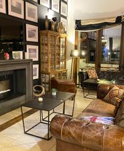 Sala acogedora con sofás de cuero, chimenea, mesa de centro y cuadros en la pared.