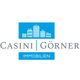 Logo von Casini Görner Immobilien mit blauen Gebäudesymbolen und Schriftzug in Grau.