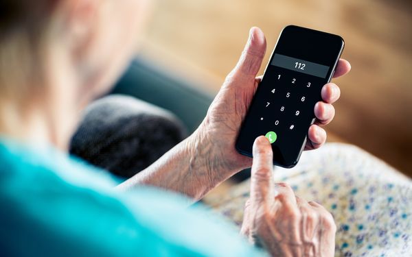 Eine ältere Damen wählt die Nummer des Notrufs. Auf dem Display des Smartphones ist die 112 zu erkennen.