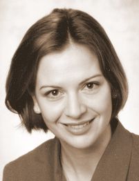 Eine lächelnde Frau mit schulterlangem Haar in einem sepiafarbenen Foto.