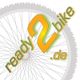 Graues Fahrrad-Rad im Hintergrund, Text "ready 2 bike .de" in Orange und Grün.
