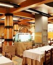 Restaurante acogedor con mesas vestidas y decoración de madera y barriles en las paredes.