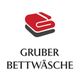 Rotes Handtuch-Logo mit Text "Gruber Bettwäsche" darunter.