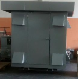 Estrutura metálica cinza com porta central e paredes laterais inclinadas. Fundo laranja.