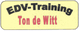 Gelbes Schild mit dem Text "EDV-Training Ton de Witt" in schwarz und rot.