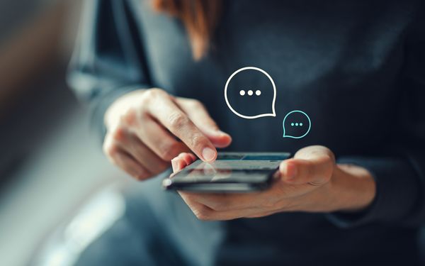 Eine Mitarbeiterin verwendet einen WhatsApp Chanel, um mit den Kunden der Firma in Kontakt zu bleiben.