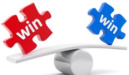 Zwei Puzzle-Teile mit "win" auf einer Schaukel, rot links, blau rechts.