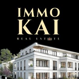 Luxuriöses, weißes Wohngebäude mit großen Fenstern, umgeben von Bäumen, nachts beleuchtet.