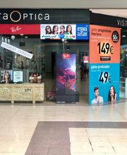 Tienda de óptica con ofertas de gafas progresivas y graduadas en un centro comercial.