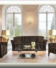 Elegantes Wohnzimmer mit Sofas, Glastisch, goldenen Lampen und großen Fensterbögen.