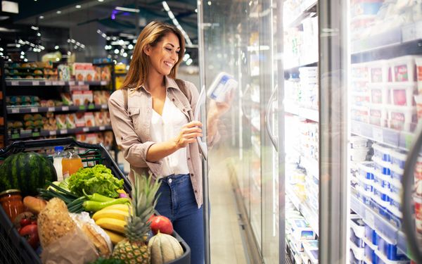 Eine Frau kauft überwiegend Obst, Gemüse und frische Lebensmittel in einem Supermarkt ein.