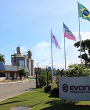 Entrada de uma fábrica com placas e bandeiras de vários países ao vento.