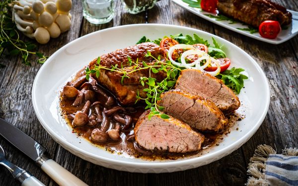 Ein gebratenes Rinderfilet liegt auf einem schön angerichteten Teller, zwischen einem Herbstsalat und einer Pfifferling Soße.