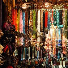 A vibrant display of assorted beaded necklaces and jewelry hanging in a market stall.