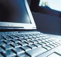 Nahaufnahme einer Laptop-Tastatur mit verschwommenem Bildschirm im Hintergrund.