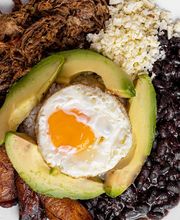 Plato de pabellón criollo con carne desmechada, plátano, huevo frito y aguacate.