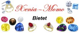 Eine Sammlung bunter Edelsteine und Ringe mit dem Schriftzug "Xenia-Momo Bietet".